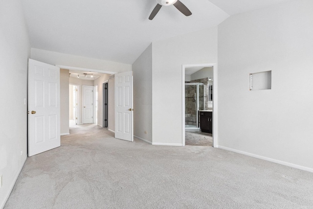 unfurnished bedroom featuring carpet, baseboards, connected bathroom, and lofted ceiling