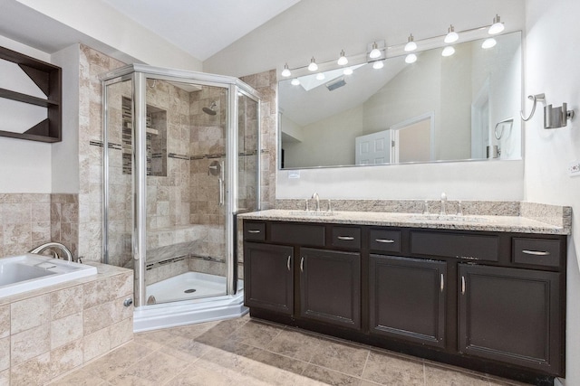 bathroom with a shower stall, a garden tub, a sink, and vaulted ceiling