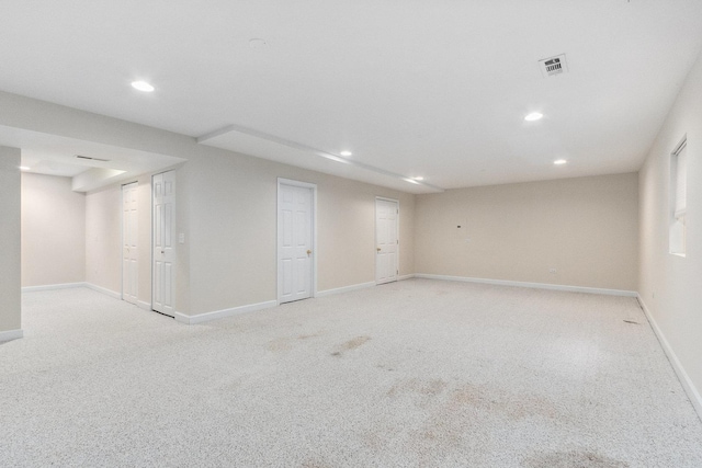 finished basement featuring light carpet, visible vents, and recessed lighting