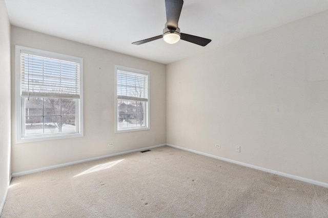 empty room featuring carpet flooring, baseboards, and visible vents