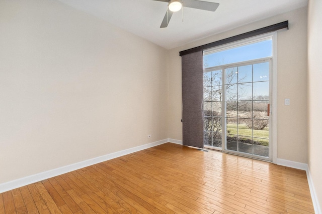 empty room with visible vents, hardwood / wood-style flooring, baseboards, and a ceiling fan