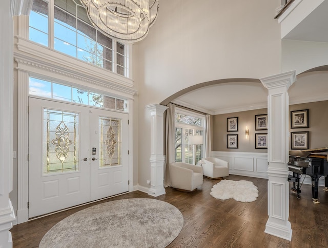 entrance foyer featuring a wealth of natural light, arched walkways, and decorative columns