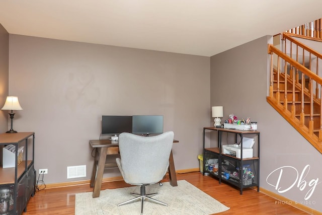 office area with baseboards, visible vents, and wood finished floors