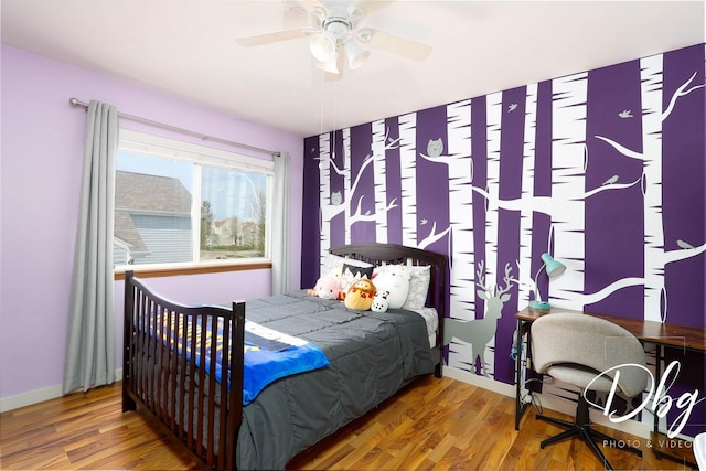 bedroom with a ceiling fan, baseboards, and wood finished floors