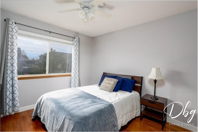 bedroom featuring baseboards, ceiling fan, and wood finished floors