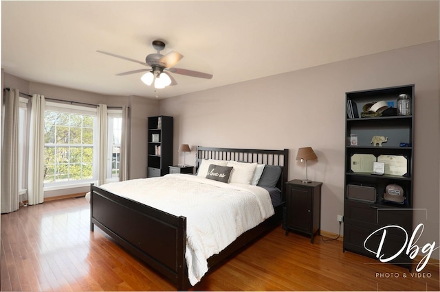 bedroom with a ceiling fan, baseboards, and wood finished floors