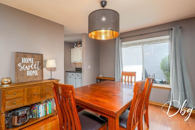 dining area featuring baseboards and light wood finished floors