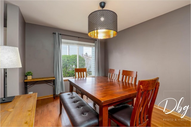 dining area with baseboards and wood finished floors