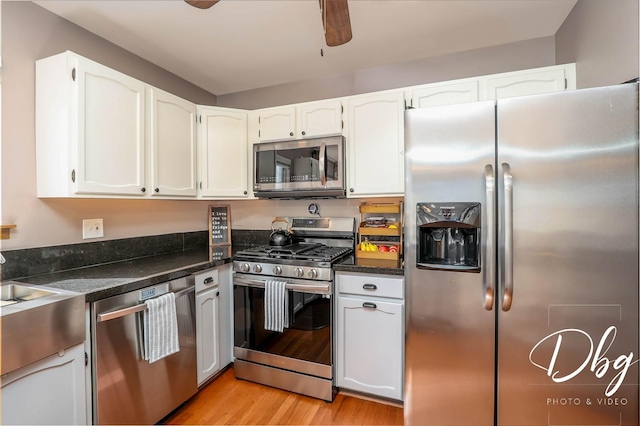 kitchen featuring light wood-style floors, a ceiling fan, white cabinetry, and stainless steel appliances