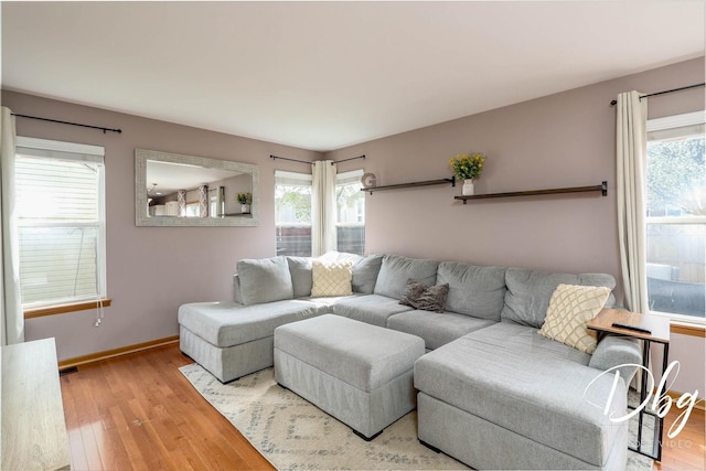 living room with baseboards, visible vents, and wood finished floors