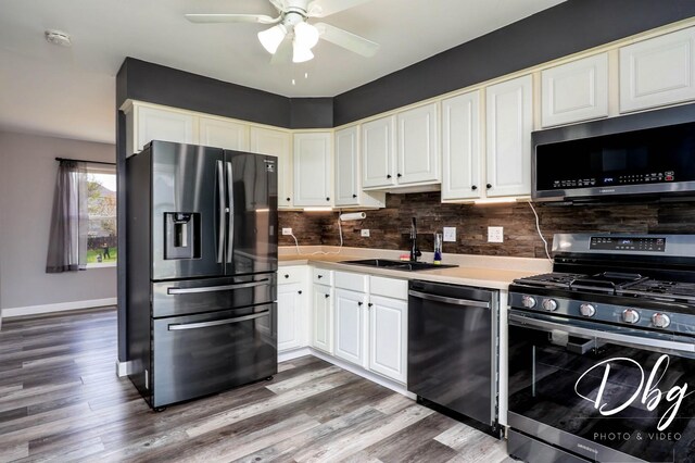 2272 Iroquois Ln, Round Lake Heights, IL 60073 - kitchen featuring appliances with stainless steel finishes, a sink, a ceiling fan, wood finished floors, and backsplash