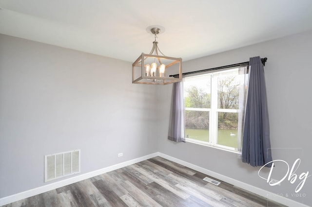 2272 Iroquois Ln, Round Lake Heights, IL 60073 - unfurnished dining area with wood finished floors, a chandelier, and visible vents