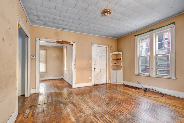 empty room with baseboards and hardwood / wood-style floors