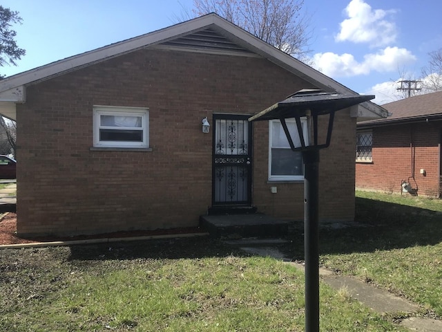 view of front of home with brick siding and a front lawn