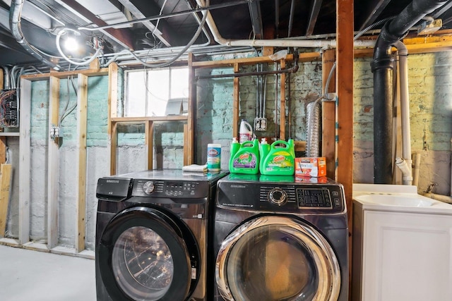 clothes washing area featuring separate washer and dryer and laundry area