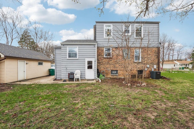 back of house featuring a lawn, central AC, brick siding, and a patio area