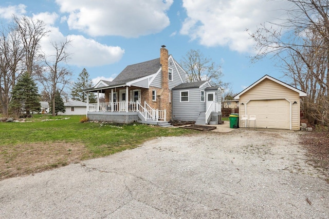 view of front of house with a chimney, covered porch, an outbuilding, driveway, and a detached garage