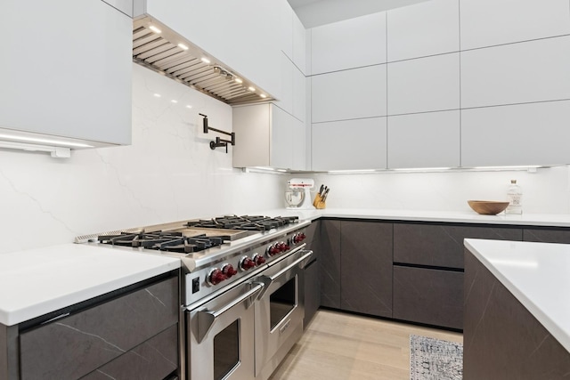 1431 N Mohawk St, Chicago, IL 60610 - kitchen featuring double oven range, modern cabinets, custom range hood, and white cabinetry