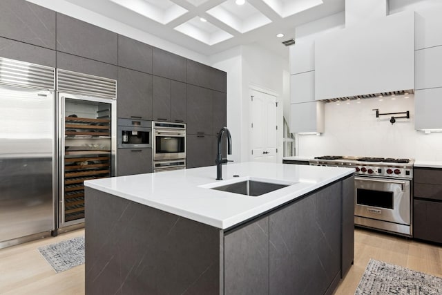 1431 N Mohawk St, Chicago, IL 60610 - kitchen with a sink, stainless steel appliances, modern cabinets, beam ceiling, and light wood-style flooring