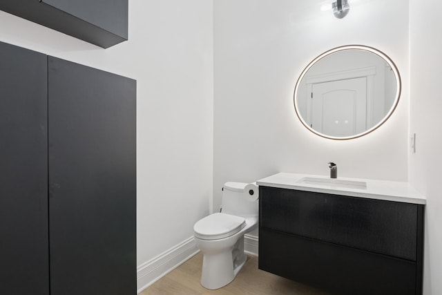 1431 N Mohawk St, Chicago, IL 60610 - half bathroom with vanity, toilet, baseboards, and wood finished floors