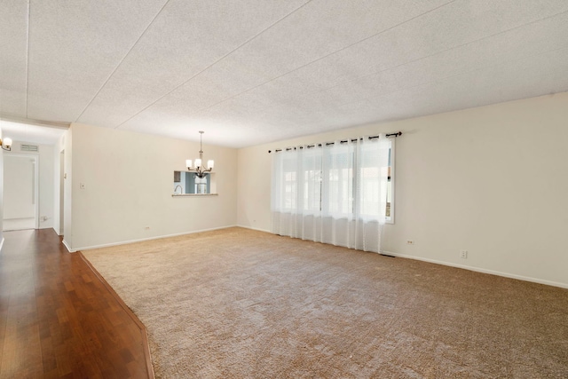 9810 Mill Dr W Unit 1B, Palos Park, IL 60464 - carpeted spare room featuring wood finished floors, baseboards, a textured ceiling, and a notable chandelier