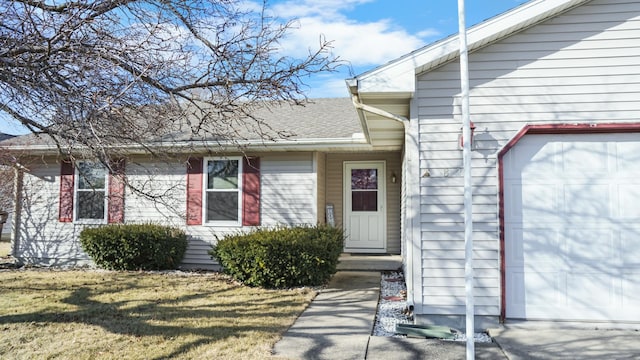 821 Park Dr, Rantoul, IL 61866 - entrance to property featuring roof with shingles, an attached garage, and a lawn