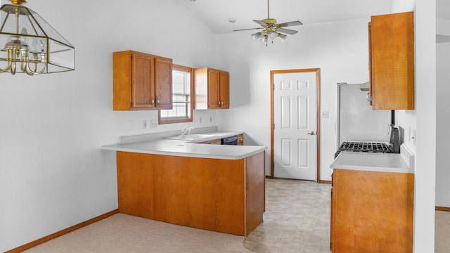 821 Park Dr, Rantoul, IL 61866 - kitchen with brown cabinetry, light countertops, a peninsula, freestanding refrigerator, and high vaulted ceiling