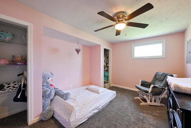bedroom featuring a closet, dark colored carpet, baseboards, ceiling fan, and a textured ceiling