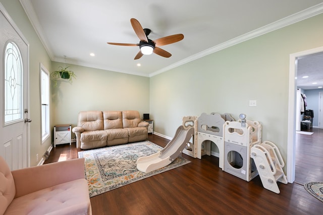 living room with crown molding, ceiling fan, baseboards, and wood finished floors