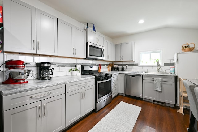 kitchen featuring decorative backsplash, recessed lighting, gray cabinets, a sink, and stainless steel appliances