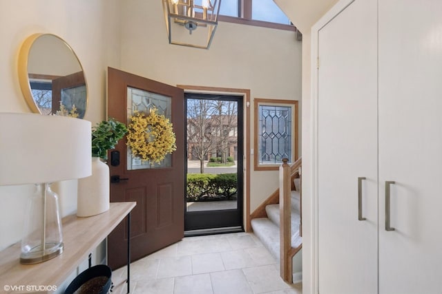2828 Ashton Ct, Westchester, IL 60154 - foyer featuring a towering ceiling, an inviting chandelier, stairs, and light tile patterned floors