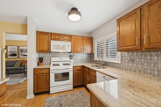 2828 Ashton Ct, Westchester, IL 60154 - kitchen featuring a sink, white appliances, decorative backsplash, light wood-style flooring, and brown cabinetry