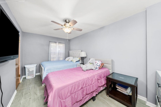bedroom featuring light wood-type flooring, baseboards, and ceiling fan