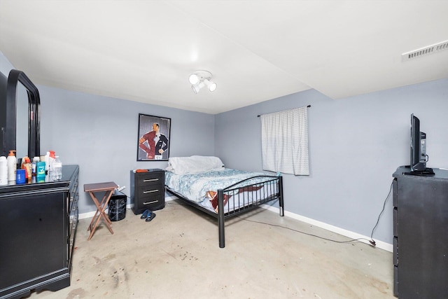 bedroom with baseboards and unfinished concrete floors