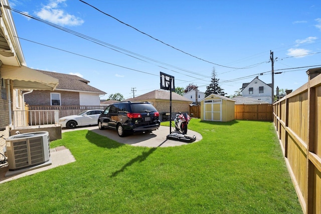 view of yard featuring central AC, a storage shed, and an outbuilding