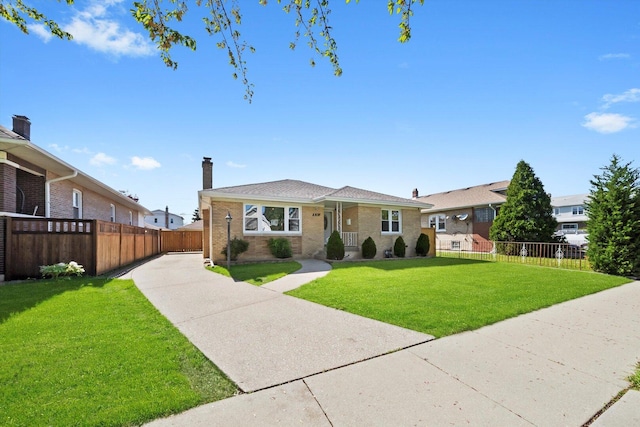 bungalow featuring a chimney, brick siding, and driveway
