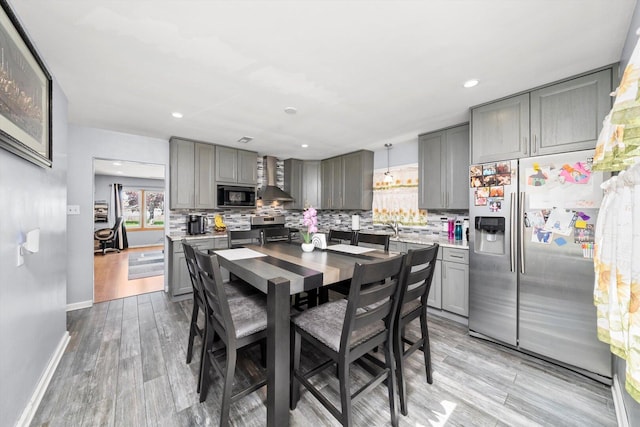dining space featuring baseboards, light wood-style floors, recessed lighting, and a chandelier