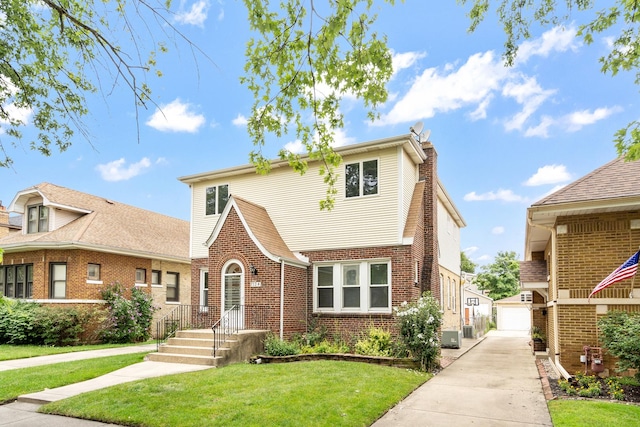 7324 W Lunt Ave, Chicago, IL 60631 - tudor home with brick siding, an outbuilding, a front lawn, and a garage