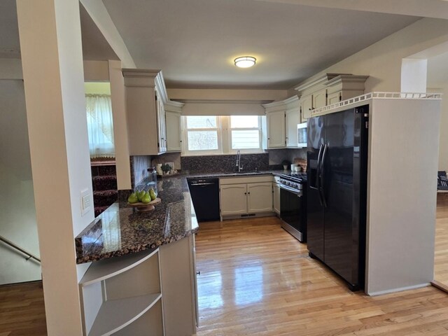 7324 W Lunt Ave, Chicago, IL 60631 - kitchen featuring light wood-type flooring, a sink, dark stone countertops, and black appliances