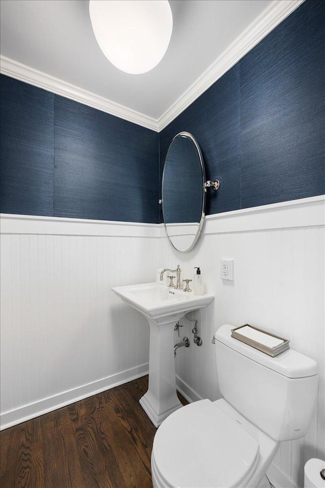 bathroom with baseboards, wainscoting, toilet, and wood finished floors