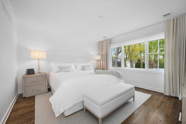 bedroom featuring baseboards, visible vents, and dark wood-style floors