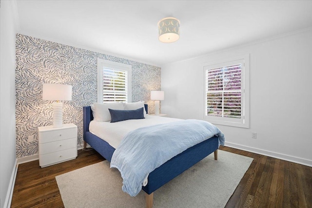bedroom with baseboards, wallpapered walls, and wood finished floors