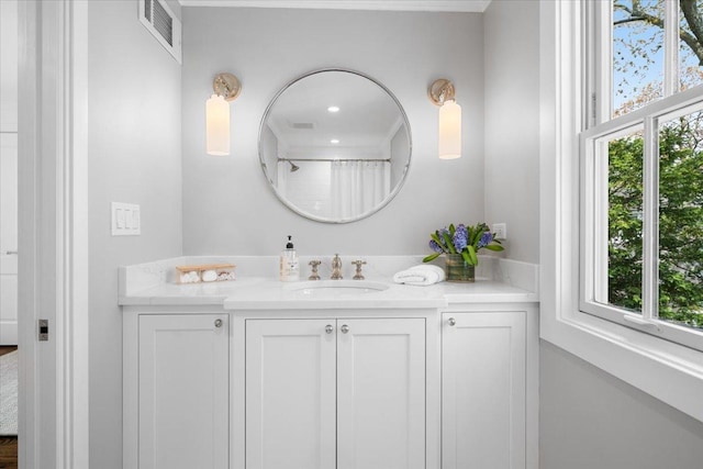 bathroom with visible vents, a healthy amount of sunlight, a shower with curtain, and vanity