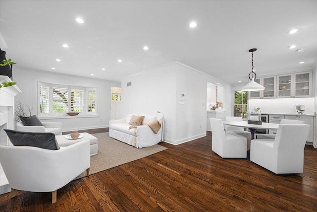 living room featuring baseboards, recessed lighting, dark wood-style floors, and a fireplace