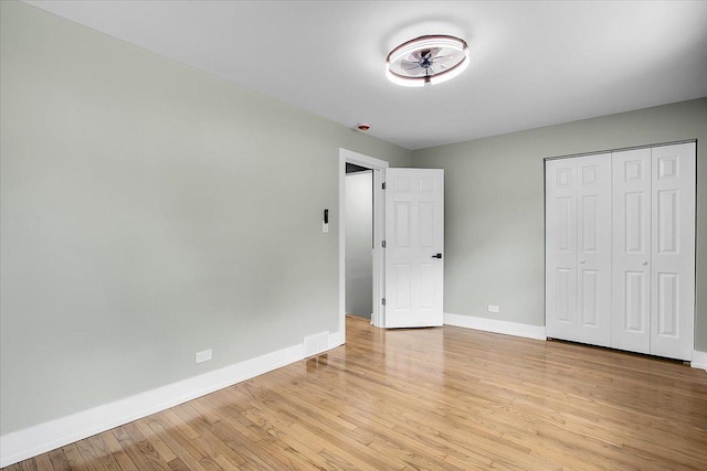 314 W 106th Pl, Chicago, IL 60628 - unfurnished bedroom with baseboards, light wood-style flooring, and a closet