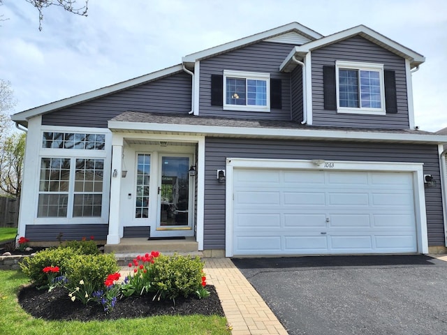 traditional home with aphalt driveway, a front lawn, and a garage