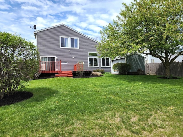 rear view of property featuring a lawn, a chimney, and a wooden deck