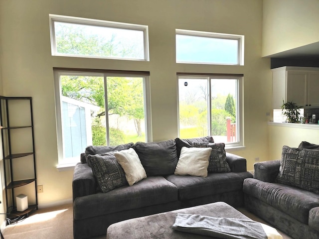 spare room with high vaulted ceiling, visible vents, an inviting chandelier, a wealth of natural light, and carpet floors