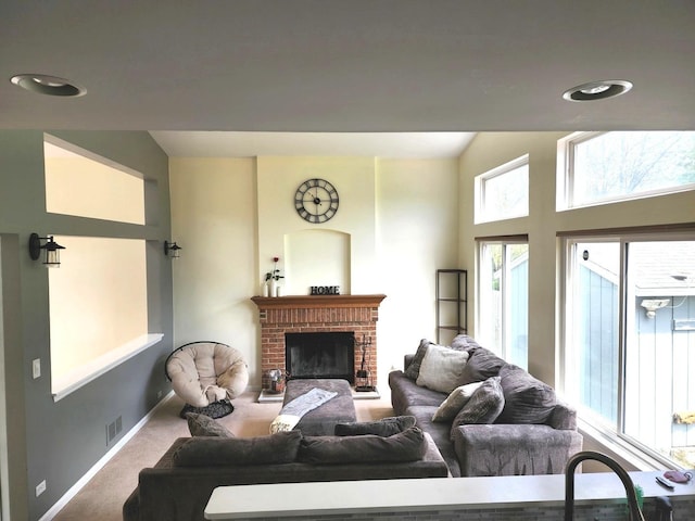 living area with high vaulted ceiling, baseboards, a brick fireplace, and carpet floors