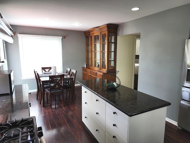 kitchen with stainless steel appliances, recessed lighting, under cabinet range hood, white cabinetry, and a kitchen island